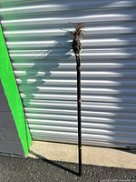 Full length view of carved tribal staff leaning against wall