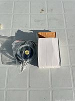 Footswitch in plastic bag beside white box