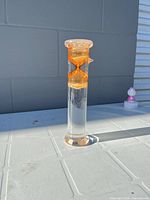 Full view of glass cylinder timer standing on table