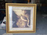 Full view of framed angel print standing on floor