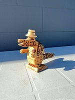 Front and side view of the carved wooden alligator figurine on tabletop