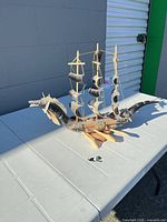 Front three-quarter view of horn and wood sailing ship sculpture on table