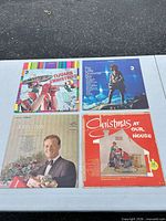 Front covers of the four Christmas vinyl LPs laid out on a table
