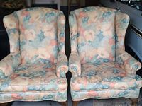 Front view of both wingback chairs showing upholstery pattern and general wear