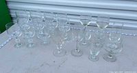 All fifteen clear glass stemmed goblets arranged on tabletop