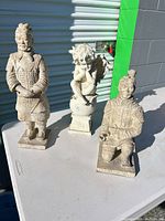 All three garden statues on table outdoors