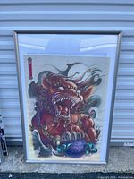 Full view of framed Fu lion print with silver frame and mat