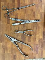 All four stainless steel hand pliers on wood surface