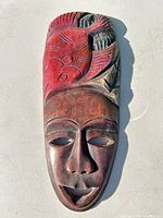 Front view of carved wood mask showing design and coloration