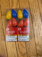 Sealed retail packages of two identical LED bulb necklaces showing six multicolour bulbs each