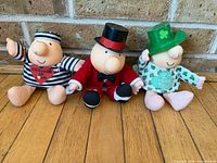 Front view of all three Ziggy dolls seated side by side