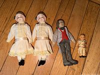 Front view of five dolls laid on floor