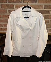 Front view of ivory faux leather double-breasted jacket on hanger showing overall style and condition.