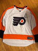 Front view of Flyers jersey showing logo, colors, and letter A