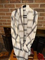Full view of plaid poncho wrap hanging