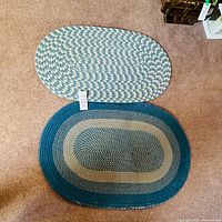 Top view of two oval braided rugs, different color schemes