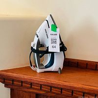 Side view of Black+Decker steam iron on wooden shelf