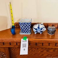 Overall lot showing plant pot, piggy bank, trinket box with tape measure for scale