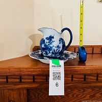 pitcher standing in matching bowl with tape measure showing scale