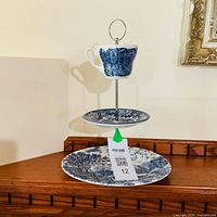 Two-tier serving stand with lower plate and upper teacup in blue and white pattern