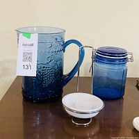 Overall lot showing cobalt blue patterned pitcher, cobalt blue lidded jar, and white ramekin in metal stand