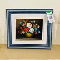 Front view of framed floral painting in blue frame