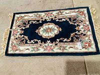 Front view of rectangular floral rug showing overall design and fringe