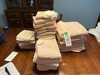 Stacks of peach bath towels, hand towels, and facecloths on table