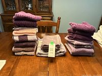 Stacks of purple and lavender towels on a wooden table
