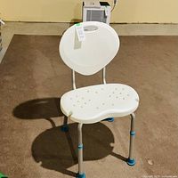 Front view of shower chair showing seat, backrest and adjustable legs