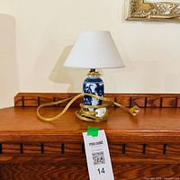 Front view of small blue and white ceramic lamp with shade and cord