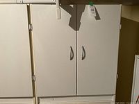 Front view of closed white two-door storage cupboard