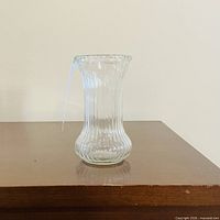 front view of clear ribbed glass vase on table