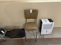 Front view of chrome chair with brown vinyl seat/back; paint splatters visible