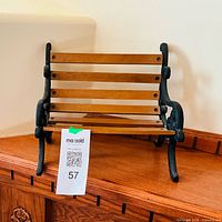 Front angle view of wooden slat and cast iron miniature bench