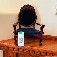 Front view of wooden doll chair showing velvet backrest and seat
