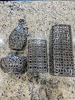 All four silver chrome openwork vases displayed together