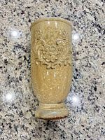 Full view of ceramic vase standing upright showing glaze color and embossed floral motif