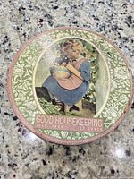 Lid showing Good Housekeeping July 1933 artwork and floral border