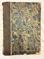 Front cover showing quarter leather spine and marbled boards with heavy wear