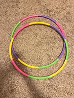 Both hula hoops lying flat showing full circular form and color segments