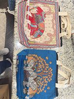 Overview of both tote bags showing designs, handles and size relative to surroundings