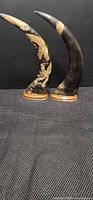 Pair of carved buffalo horns standing on wood bases