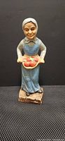 Front view of ceramic woman figurine holding apples