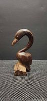 Front three-quarter view of wooden swan figurine on base