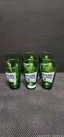 Front view of six green Rolling Rock pint glasses