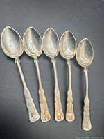 Five matching Chinese silver teaspoons laid side by side