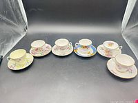 Six floral bone china teacup and saucer sets displayed