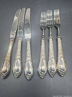 Full view showing three dessert knives and three dessert forks with matching pattern