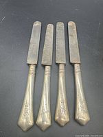 Four knives with silver handles and steel blades, full view